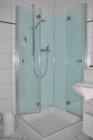A glass-enclosed shower with a handheld showerhead and a handheld faucet. - Rennsteighotel Herrnberger Hof (Neuhaus am Rennweg)