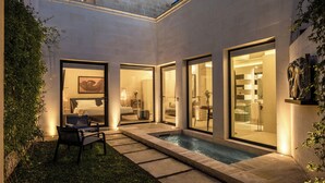 Un hotel moderno con piscina, area salotto esterna e ampie finestre.
