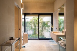 Enjoy a serene bathroom retreat with a spacious shower, dual sink, and garden view.