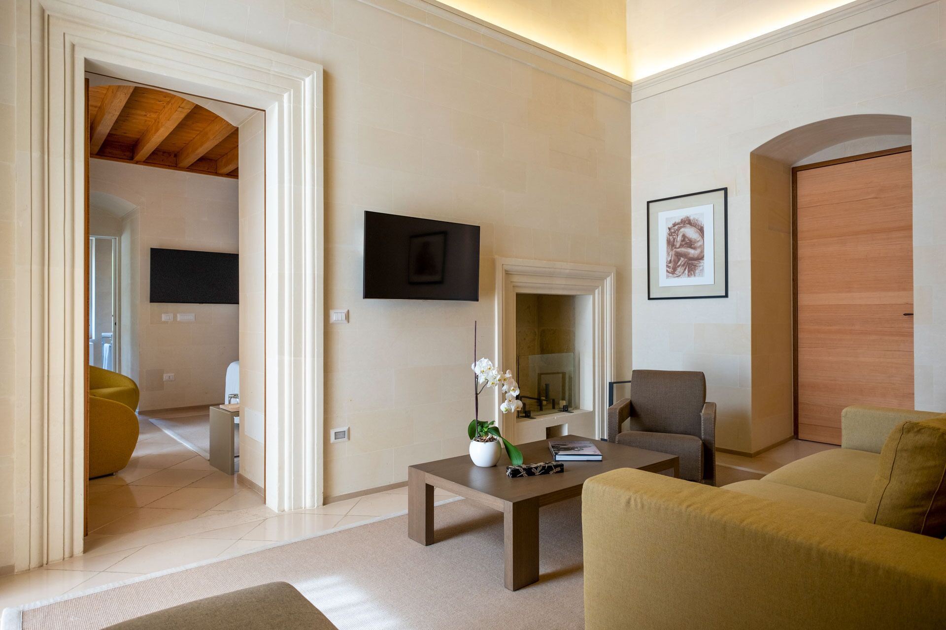 Un soggiorno moderno con un divano, un tavolino, una TV e un quadro appeso al muro.