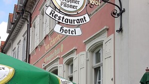 Een gebouw in traditionele Europese stijl, met een bord dat aangeeft dat het een restaurant en hotel is.