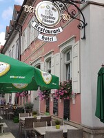 Ein traditionelles Gebäude im europäischen Stil, mit einem Schild, das angibt, dass es sich um ein Restaurant und ein Hotel handelt.