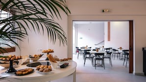Una mesa de buffet con diversos pasteles y una planta en maceta.