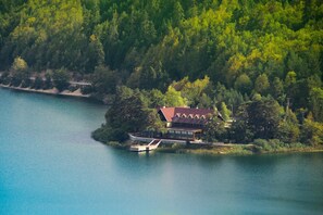 A lakeside cabin with a red roof, surrounded by dense forest, and accessible by a small dock. - Abant Kosk (Mudurnu)