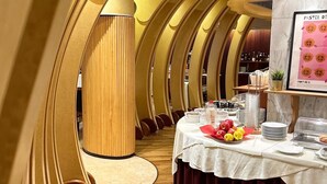 A dining area with round tables, a central column, and a wall with a framed menu. - Hotel Due Torri Tempesta (Noale)