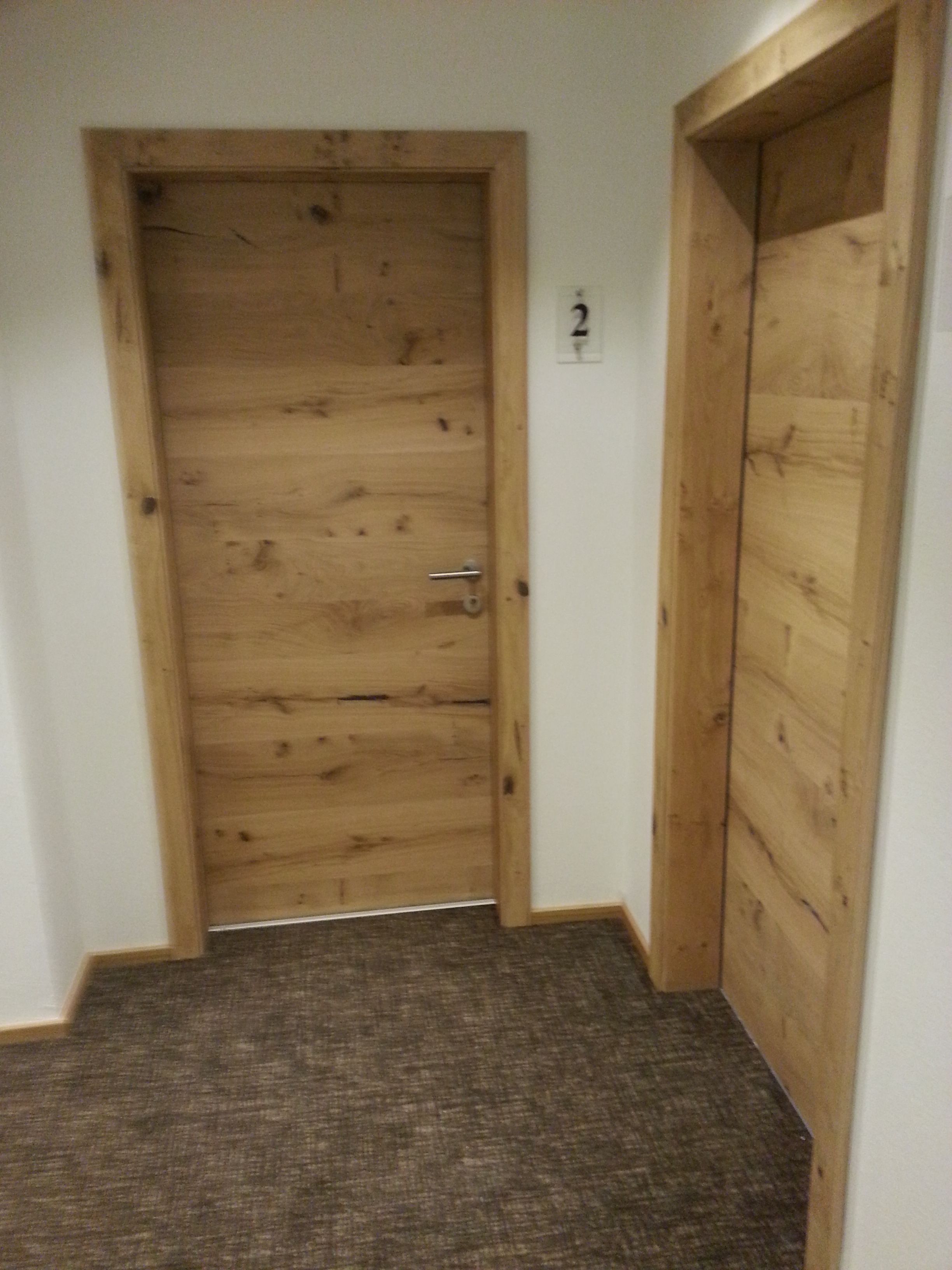 Una puerta de madera con el número 2 en la pared de al lado.