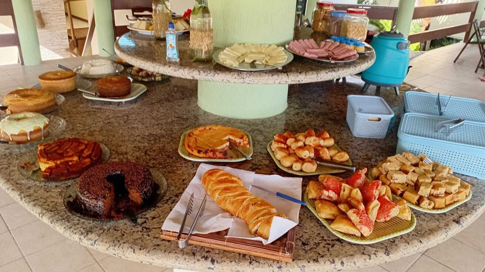 A buffet table with various dishes including cakes, pastries, and sandwiches.