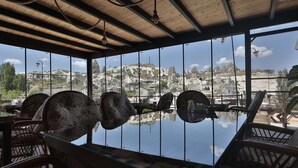 Un restaurant doté d’un plafond en bois et de grandes fenêtres offrant une vue sur un paysage montagneux.