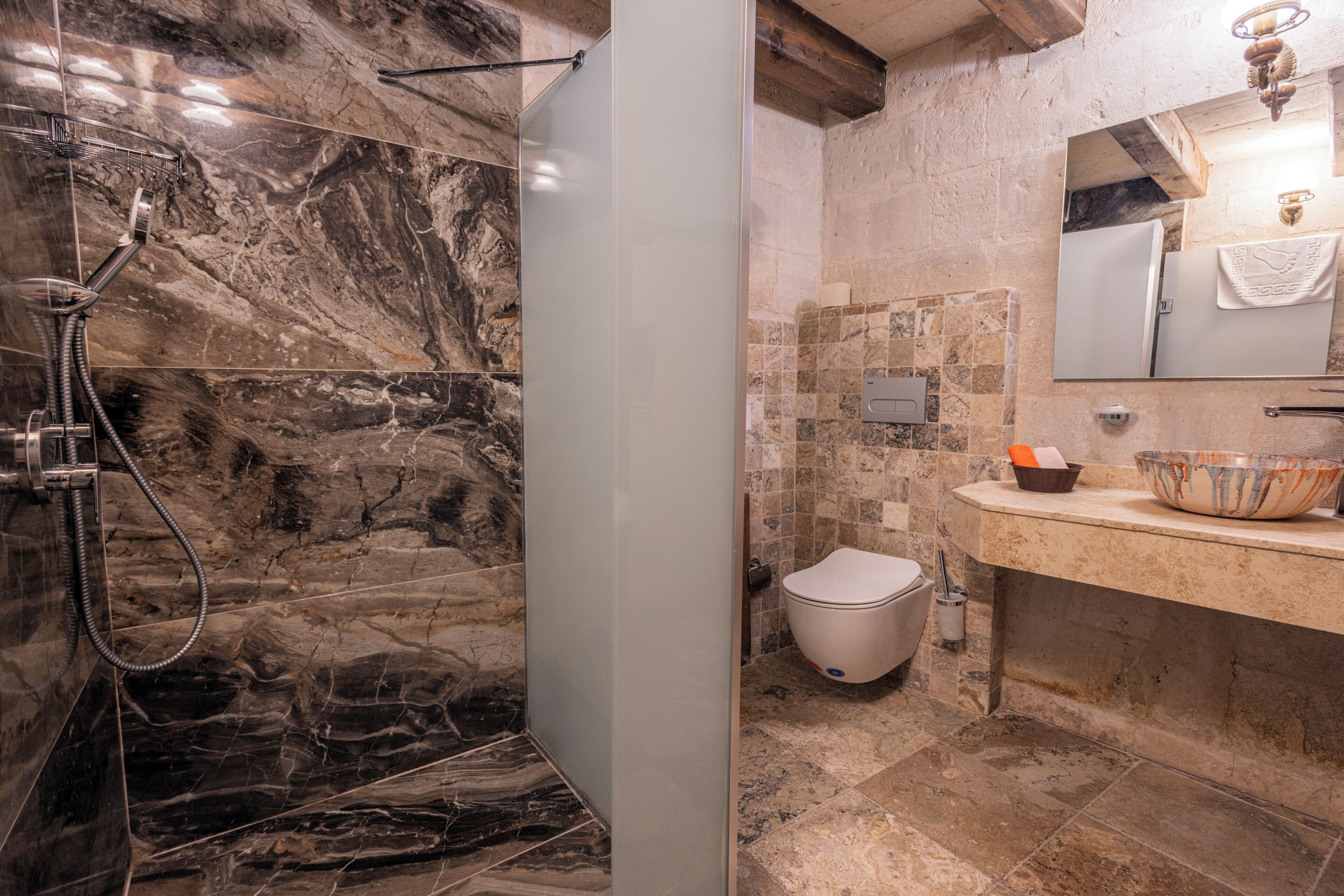 A bathroom with a shower, toilet, and sink area.