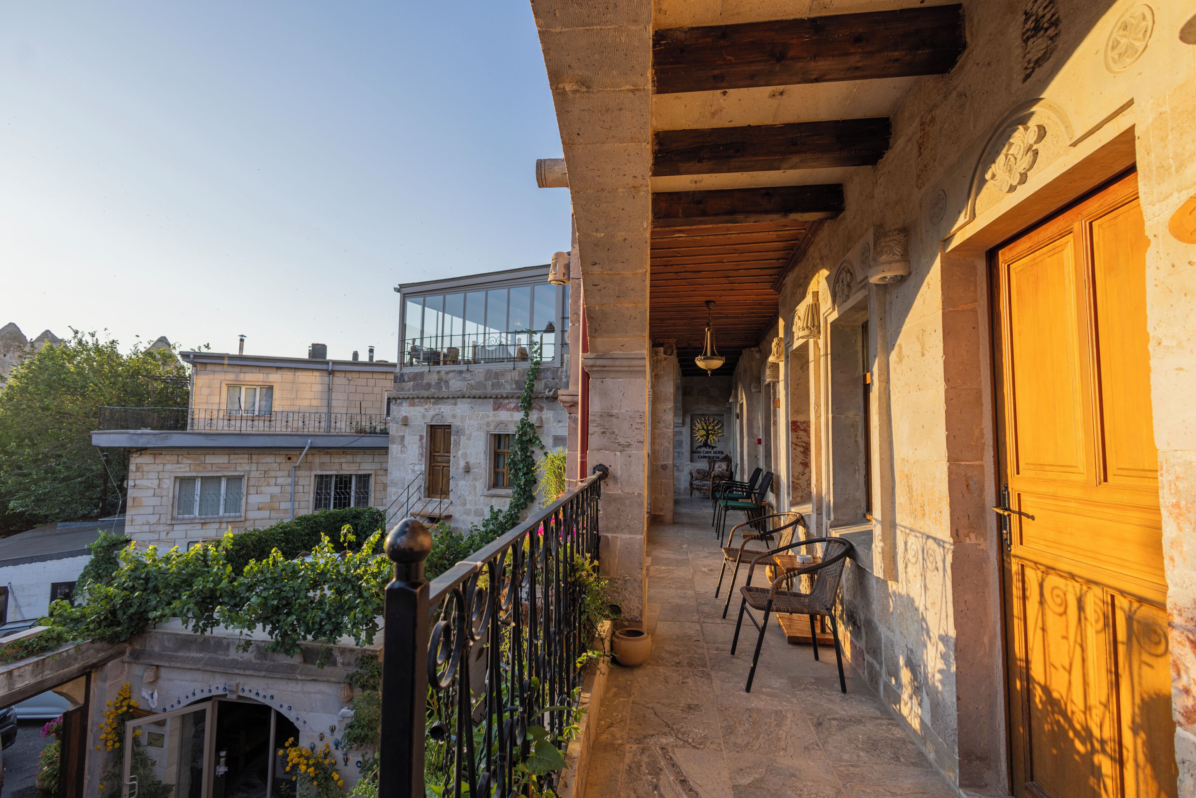 A balcony with a view of a cityscape, stone walls, and a wooden door.