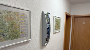 A hallway with a map, a framed picture, and a door. - Pension im Wirtshaus Himberg (Bad Honnef)