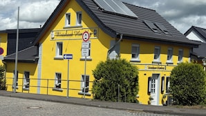 A yellow building with a sign reading "Wirtschaftshaus Himmelsteg." - Pension im Wirtshaus Himberg (Bad Honnef)