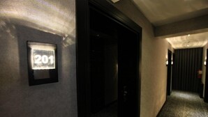A hallway with a number sign '201' on the wall, a door, and a carpeted floor. - The Black Hotel (Eskisehir)
