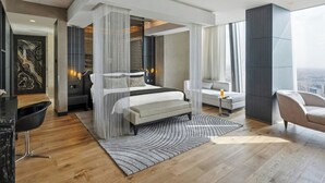 Une chambre à coucher moderne avec un lit, des tables de chevet, un canapé et un fauteuil.