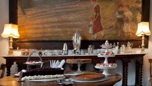 A dining table with a variety of desserts and a large painting in the background. - B&B Casa Schlatter (Florence)