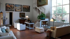A spacious living room with a staircase, a dining area, and a large window with a view. - B&B Casa Schlatter (Florence)