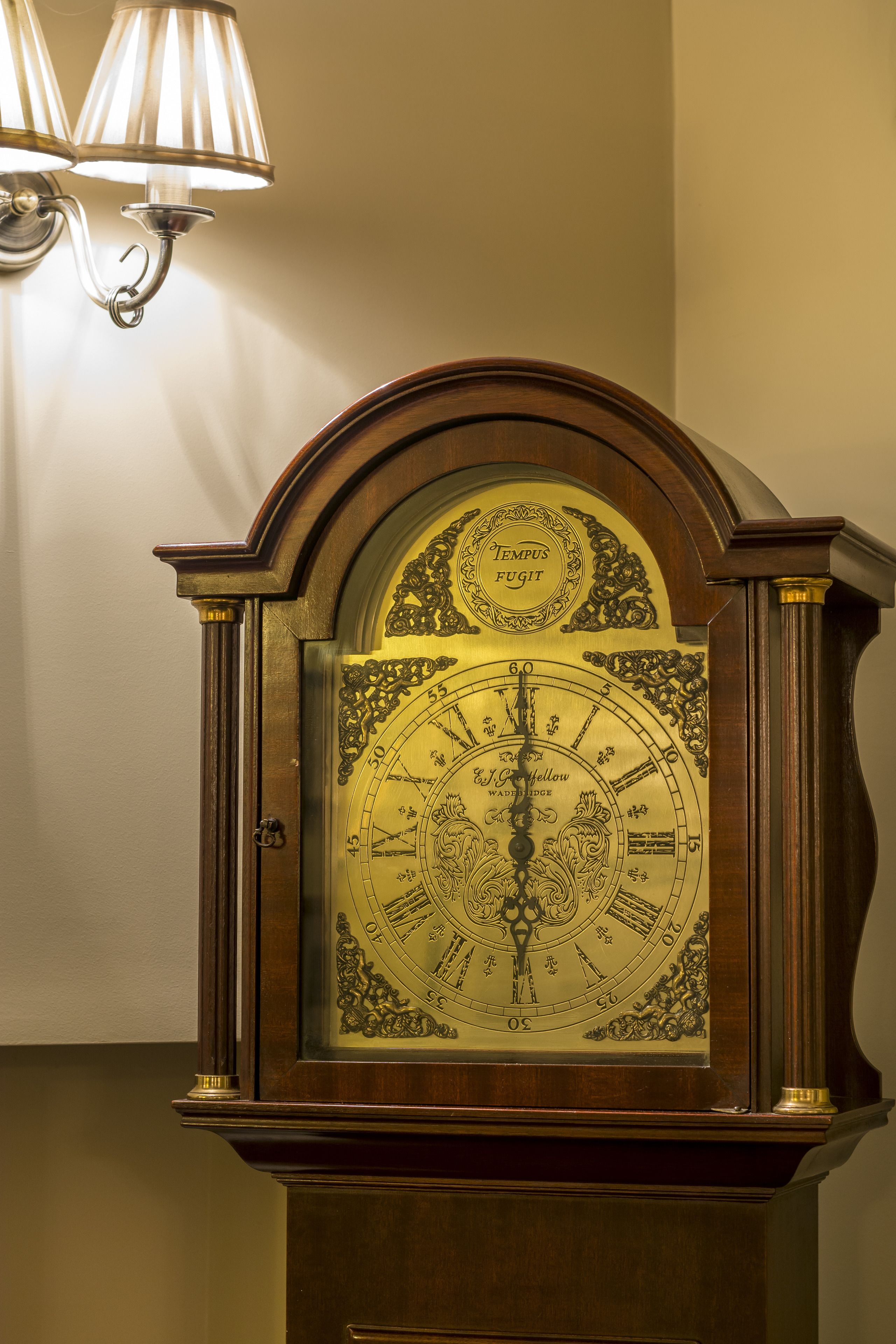 A large, ornate wall clock with a brass frame and intricate designs.