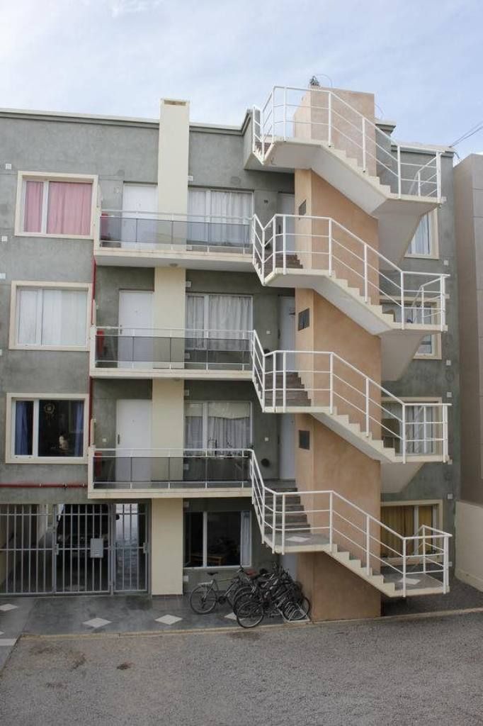 A multi-story residential building with external staircases and balconies.