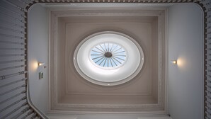 A grand staircase with a central skylight and decorative moldings. - Oporto Trendy Apartments (Porto)