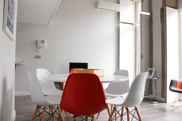 A conference room with a round table, white chairs, and a red chair. There is a box labeled "MONTES" on the table. - Oporto Trendy Apartments (Porto)