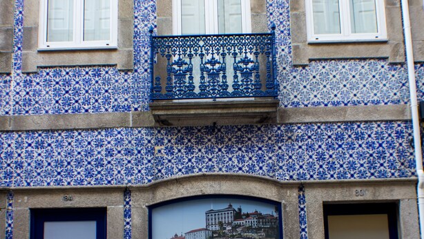 A building with blue and white patterned tiles, two dark blue doors, and a sign advertising Oporto Trendy Apartments. - Oporto Trendy Apartments (Porto)