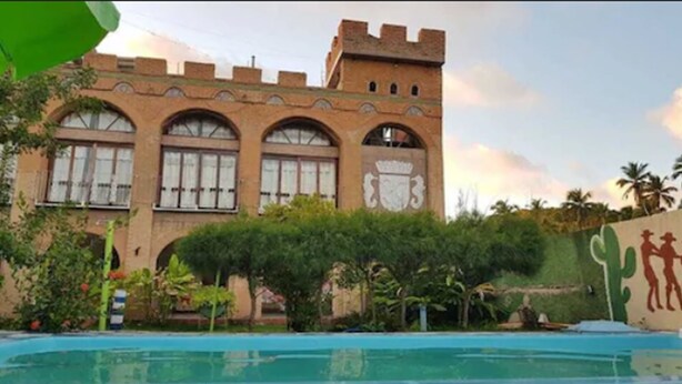 Un edificio con ventanas arqueadas y un mural en la fachada.
