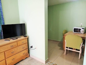 A room with a wooden dresser, a television, and a microwave on a table. - Be Inn Punta Gorda (Punta Gorda)