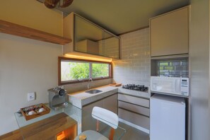 Una cocina compacta con cafetera, microondas y refrigerador.