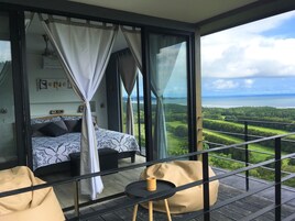 Un balcón con una cama y una mesa, con vistas a un paisaje pintoresco.