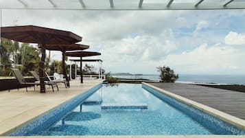 Outdoor pool, an infinity pool, open 6:00 AM to 9:00 PM, pool umbrellas