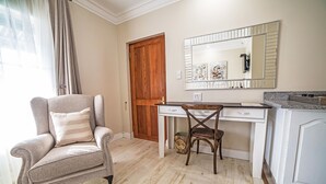 A room with a wooden door, a desk with a mirror, a chair, and a cabinet. - AnnVilla Guesthouse (Klerksdorp)