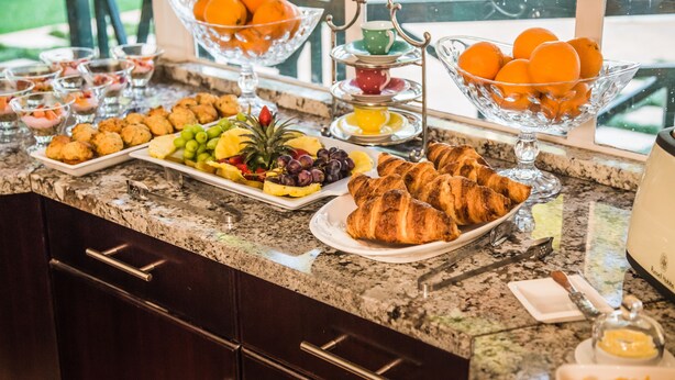 A breakfast buffet with various food items and a coffee machine. - AnnVilla Guesthouse (Klerksdorp)