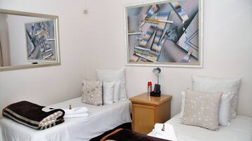Ein Hotelzimmer mit zwei Betten, einem Nachttisch und Bildern an den Wänden.