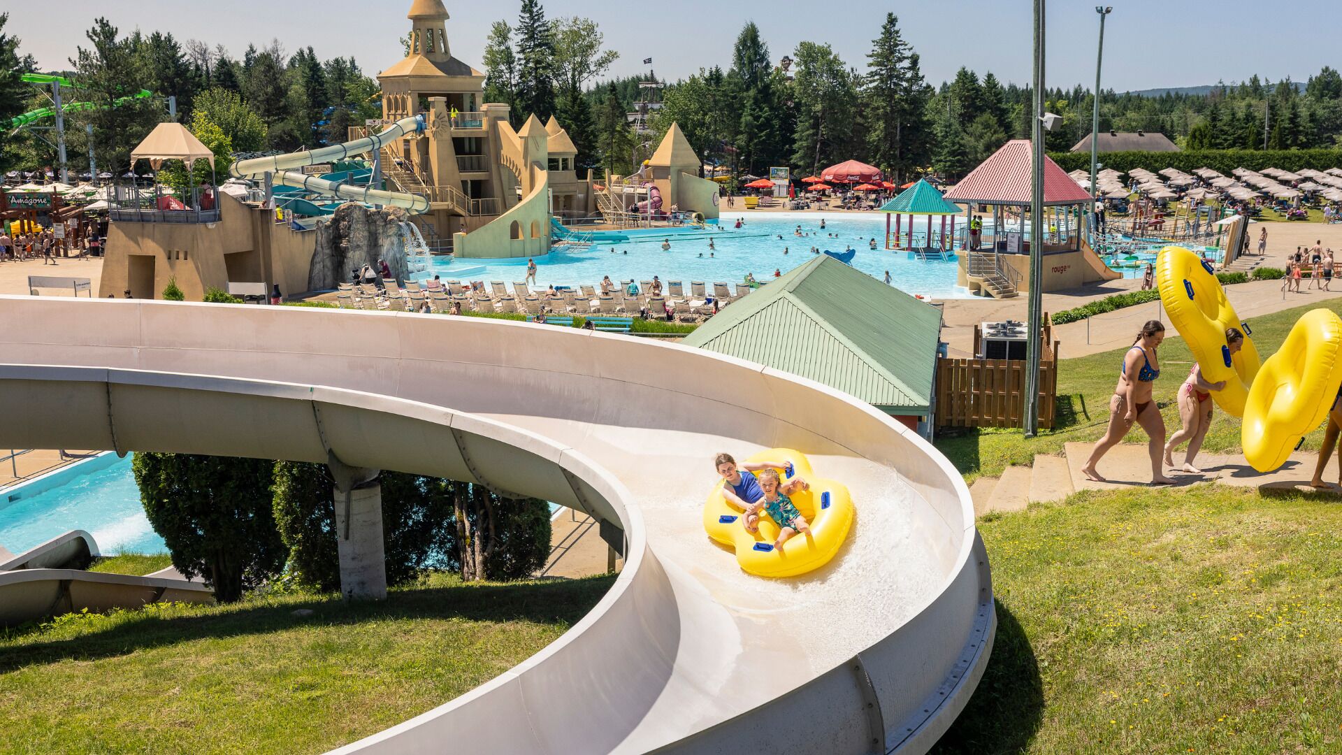 Un parc aquatique doté d’une grande piscine, d’un toboggan aquatique et de bouées gonflables.