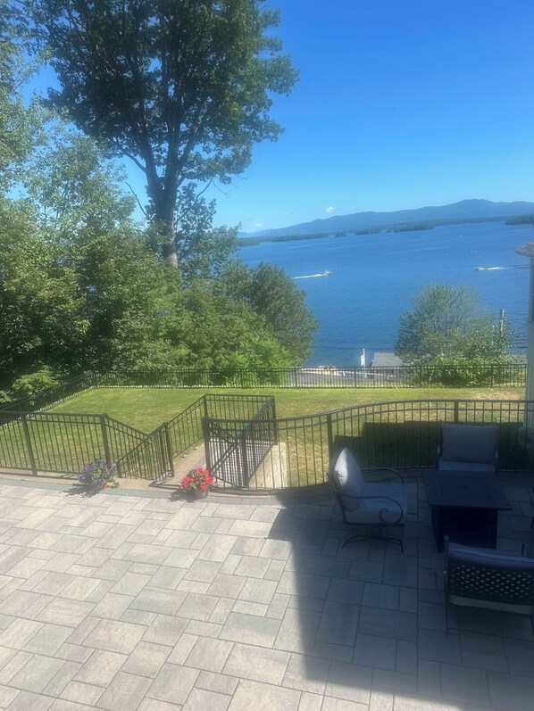 A patio with a view of a lake and mountains.