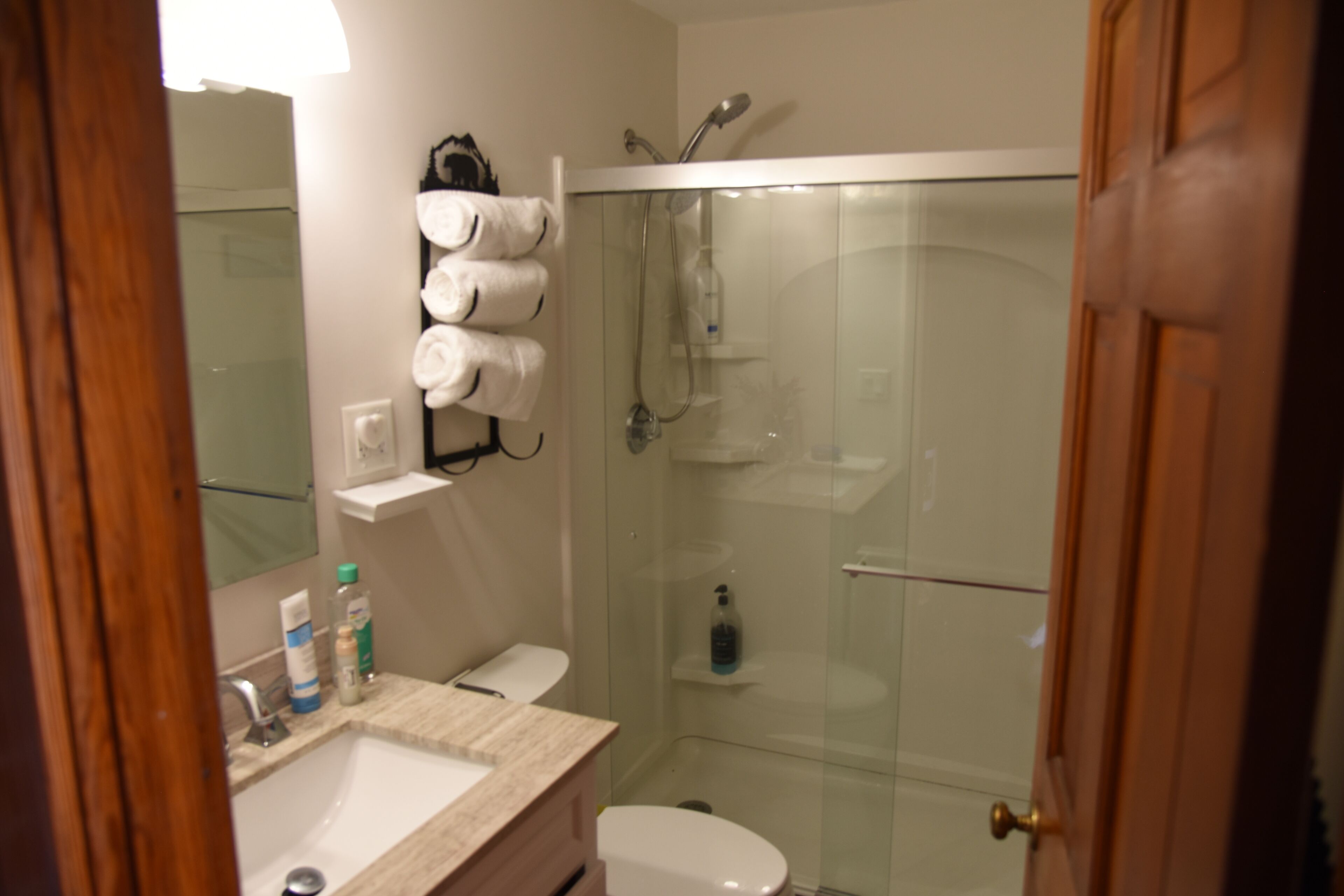 Une salle de bain équipée d’un lavabo, de toilettes et d’une douche à parois de verre.