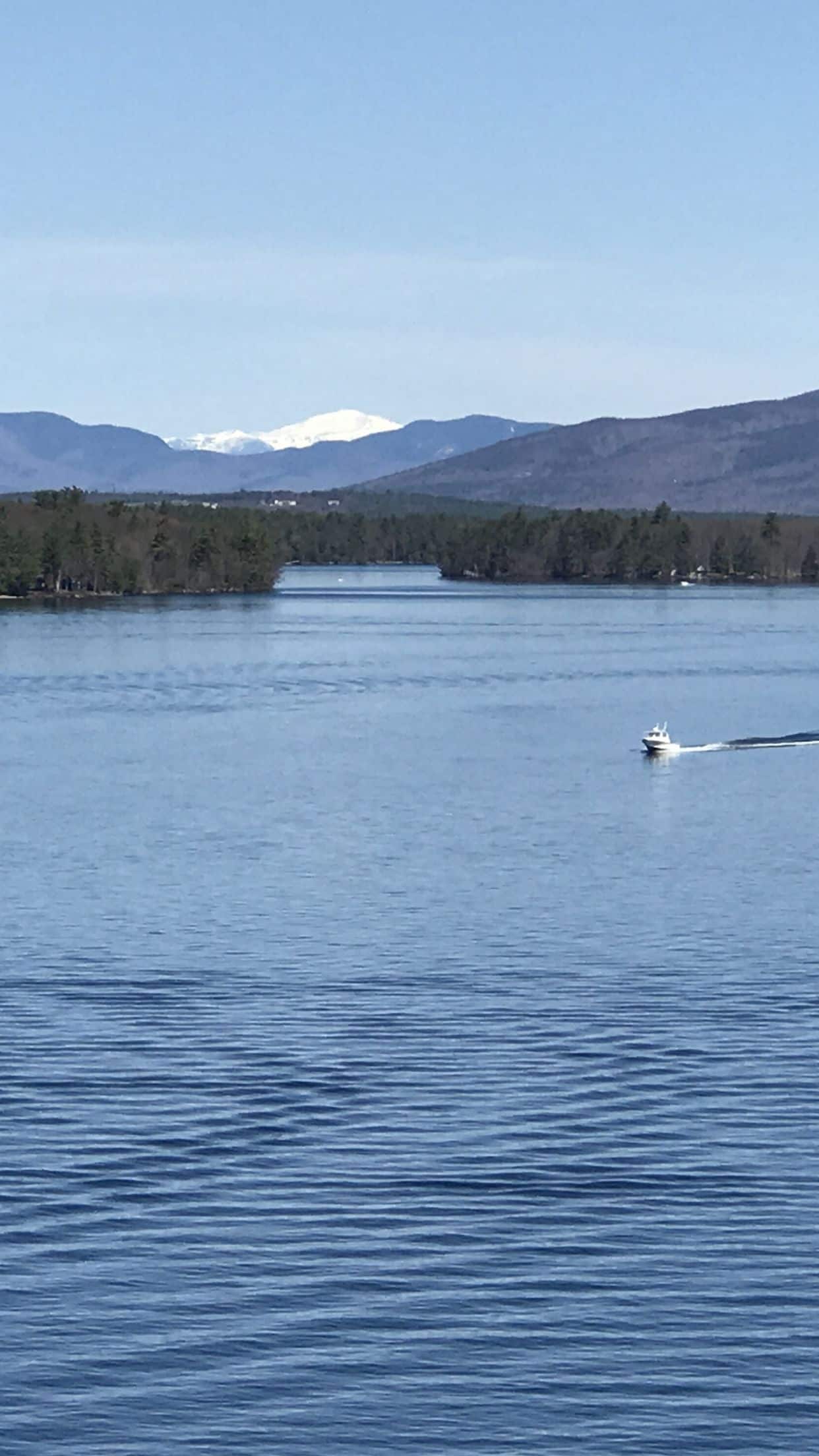 Um lago tranquilo com um barco deslizando na água.