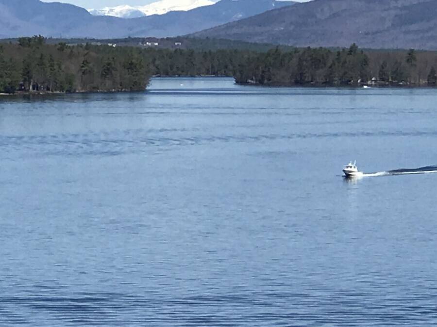 Um lago tranquilo com um barco deslizando na água.