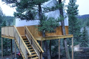 A treehouse with a wooden staircase and a white exterior. - YD Guest Ranch (Cherryville)