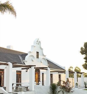 A white building with a unique architectural design, featuring a curved roof and a central tower-like structure. - Victoria Heights B and B (Wilderness)