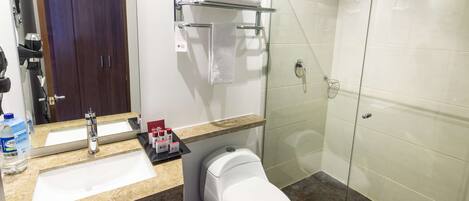 A bathroom with a sink, toilet, and glass shower enclosure.