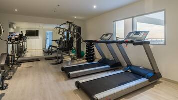 Ett gym med löpband, crosstrainers och styrketräningsutrustning.