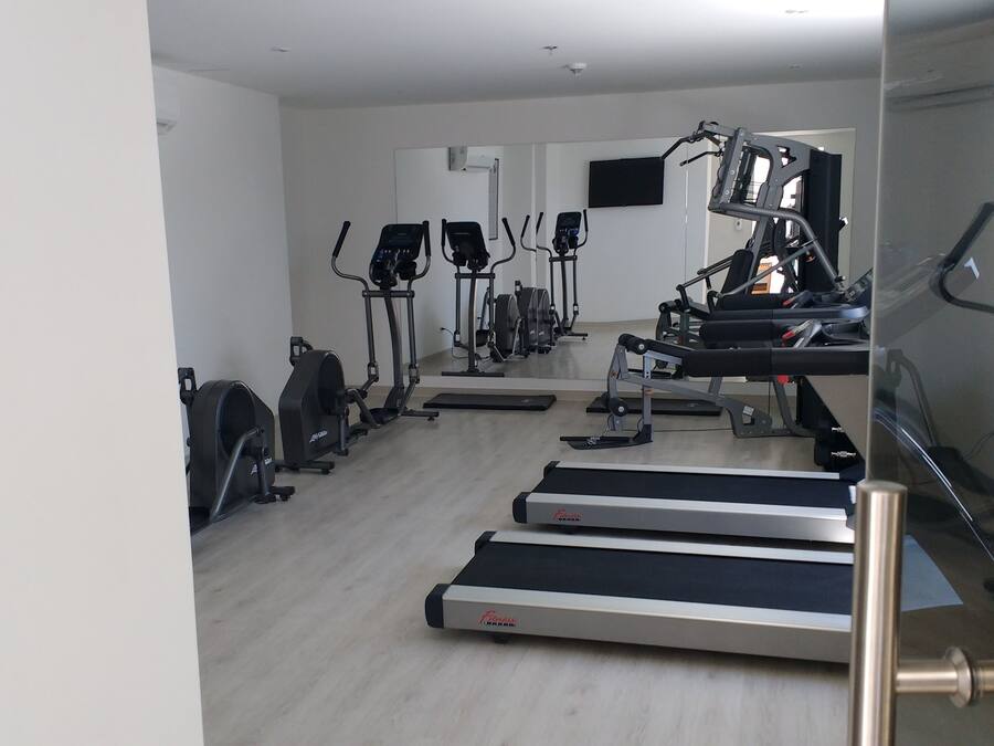 A gym with treadmills, elliptical machines, and a stationary bike.