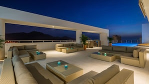 A rooftop lounge with outdoor seating and a pool.