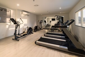 A gym with treadmills, elliptical machines, and weight equipment.