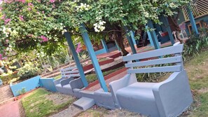 A garden with a series of steps leading to a seating area with benches. - Cabinas Marielos (Tamarindo)