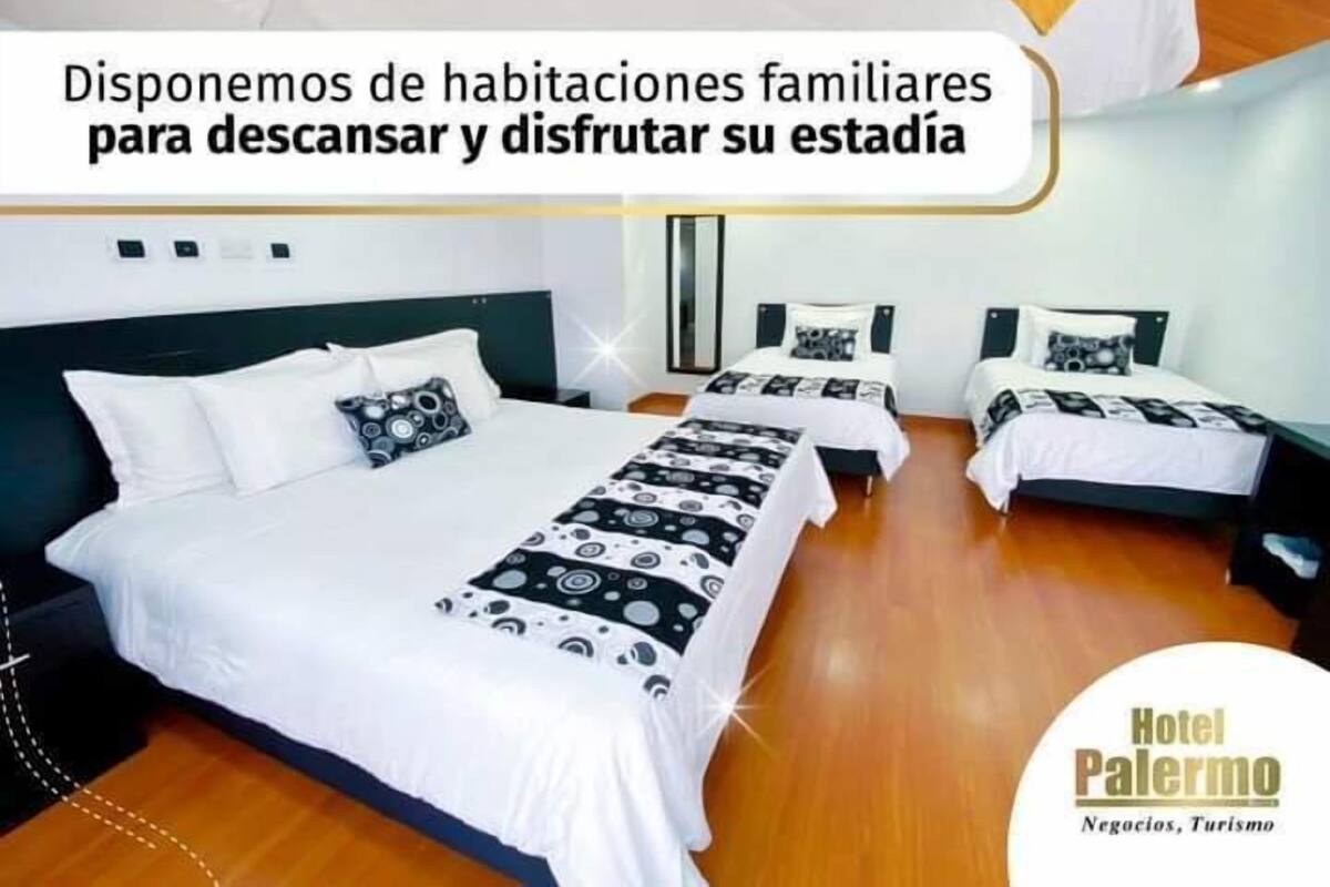 Habitación de hotel con dos camas, televisión y escritorio.