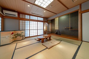 A traditional Japanese room with tatami flooring, a low wooden table, and sliding doors.