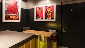 A modern room with a bar area, artwork on the walls, and a door with a geometric lock symbol. - ARTIST HOTEL - BnA HOTEL Koenji (Tokyo)