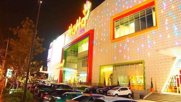 A brightly lit building with a large sign reading "Hotel". - 42 Place (Bangkok)